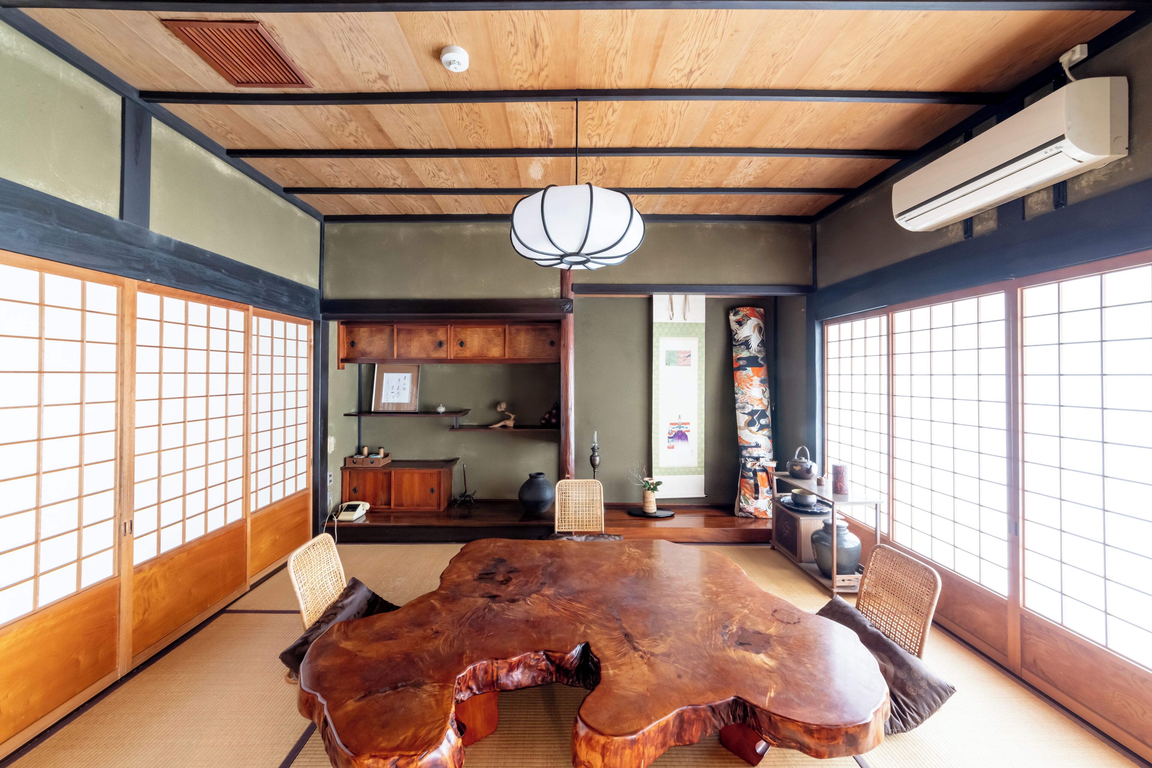 A traditional Japanese room with tatami flooring, a wooden table, and shoji screens.