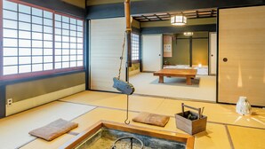 A traditional Japanese room with tatami flooring, a futon bed, a shoji screen, and a hanging lantern. - Ryori Ryokan Yamazato Ryori Isobe (Nantan)
