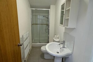 Regadera, toallas, papel de baño 