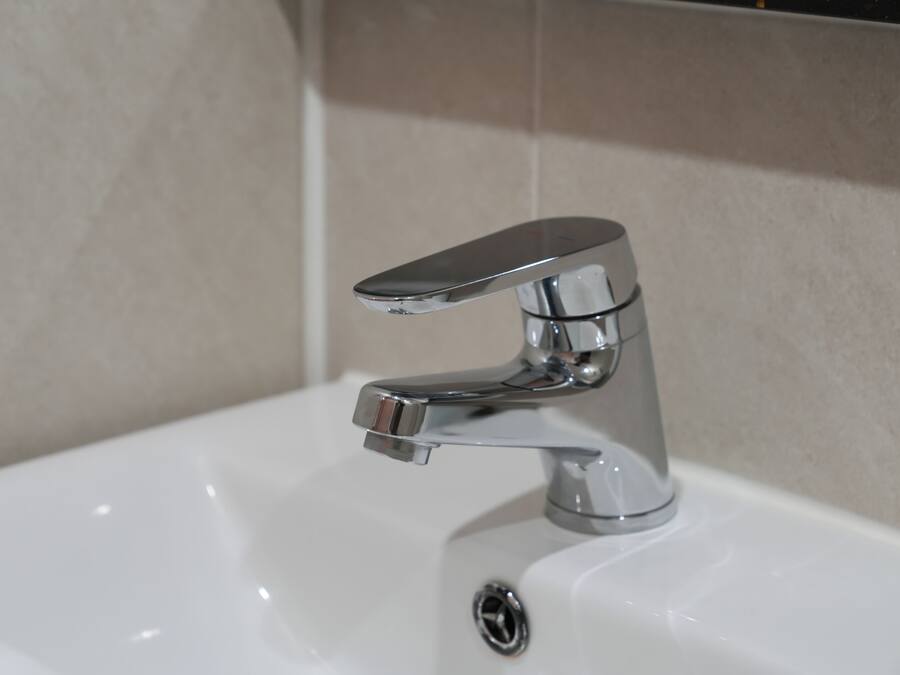 Ein Waschbecken mit chromfarbenem Wasserhahn und einem Einhebelgriff.