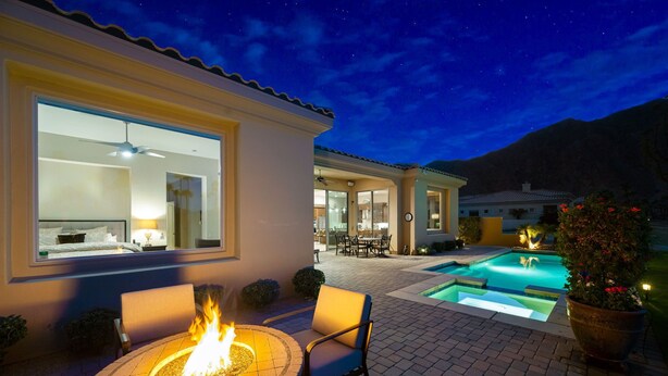 A patio with a fire pit, outdoor seating, and a swimming pool.