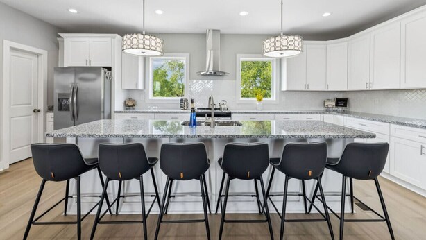 A modern kitchen with a large island, bar stools, stainless steel appliances, and pendant lighting. - Friends in Skyline Places, 10 min to Broadway, Perfect for Groups! (Nashville)