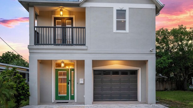 A two-story house with a balcony, a garage, and a green door. - Heart of Hyde Park Home Near Hyde Park Village, Convention, Hospital & Downtown! (Tampa)