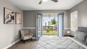 A bedroom with a bed, a chair, and a balcony with a view of the outside. - Heart of Hyde Park Home Near Hyde Park Village, Convention, Hospital & Downtown! (Tampa)