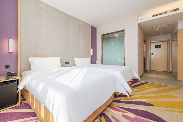 Una habitación de hotel moderna con una cama grande, un escritorio pequeño y un vestidor.
