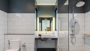 Ein modernes Badezimmer mit Toilette, Waschbecken und Dusche.