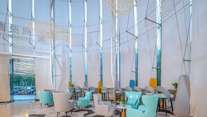 Un interior moderno con una zona de estar circular, ventanas amplias y un patrón geométrico en el suelo.