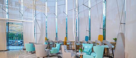 A modern interior with a circular seating area, large windows, and a geometric floor pattern.