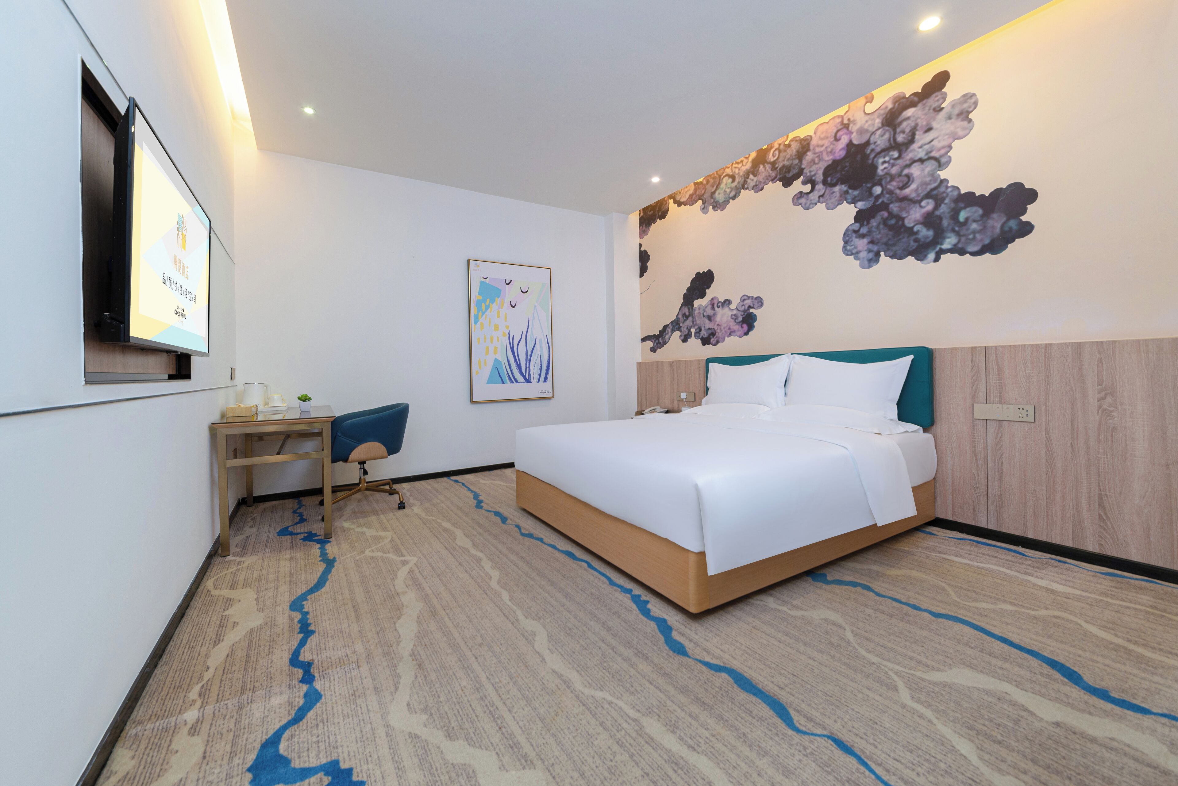 Una habitación de hotel moderna con una cama grande, un escritorio y un televisor montado en la pared.