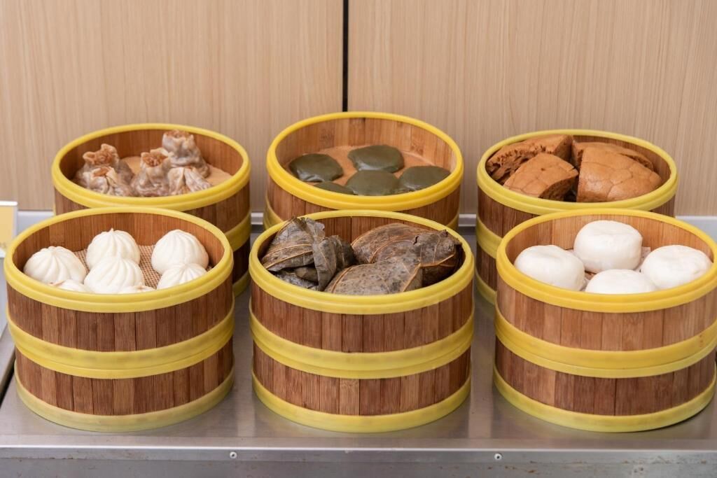 Six bamboo steamers with different types of dumplings.