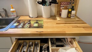 A kitchen counter with a sink, a dish soap bottle, a paper towel holder, a cookbook, and a jar of coconut oil. - Entire house close to downtown Sandusky on a quiet street (Sandusky)