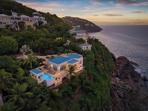A coastal property with multiple buildings, a swimming pool, and lush greenery. - Oceanfront | Peterborg | Infinity Pool | Generator (Sydneys Fancy)