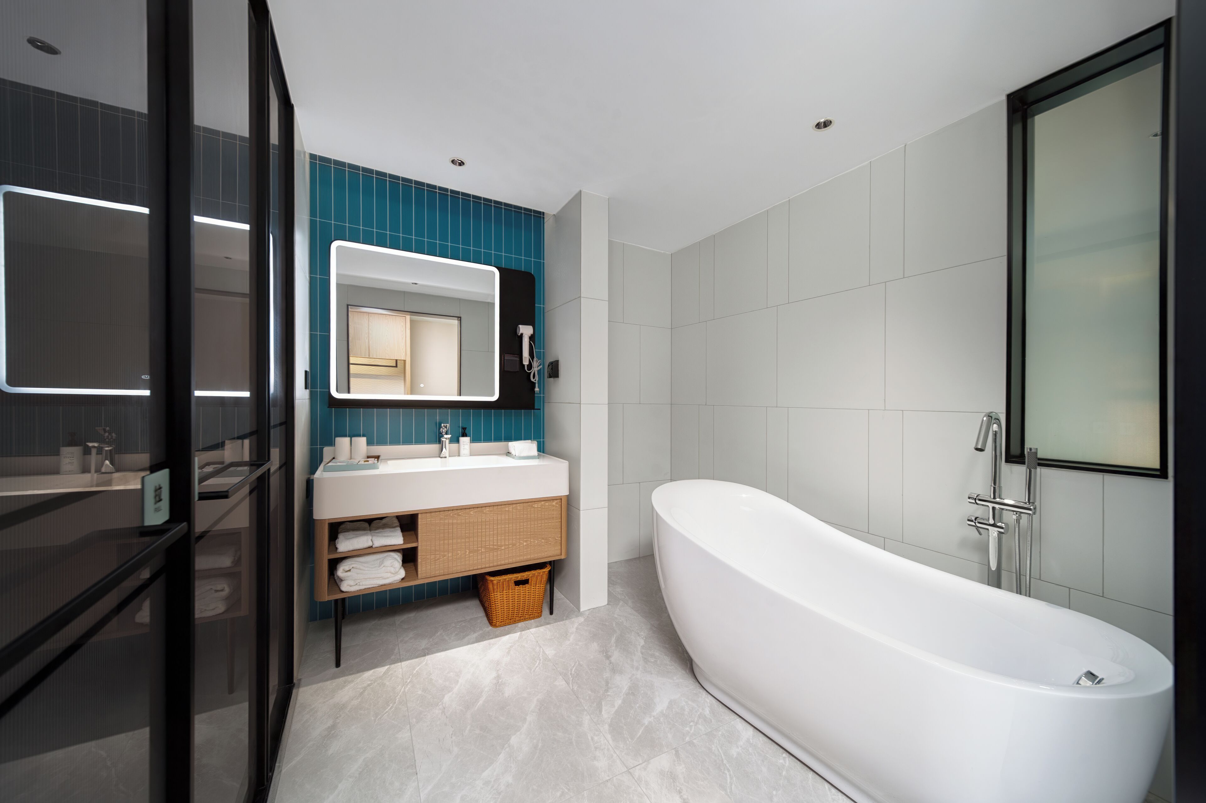 A modern bathroom with a freestanding bathtub, a vanity with a mirror, and a shower area.