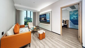 A modern hotel room with a sofa, a small table, a television, and a view of the outdoors. - Echarm International Hotel Guangzhou Huangpu Flagship Branch (Guangzhou)