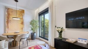 Una sala de estar moderna con comedor, un ventanal grande, un televisor de pantalla plana y un letrero que dice 'Home at Homes'.