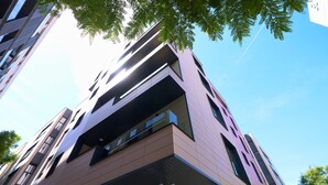 Un edificio moderno de varios pisos con techo plano y grandes ventanales.