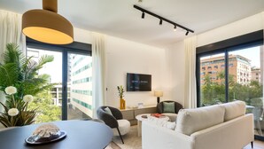 Uma sala de estar moderna com um sofá, uma mesa de jantar e uma televisão.