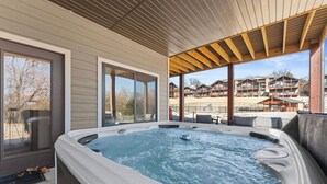 A hot tub area with a wooden ceiling and large windows overlooking a resort. - 2BR Retreat Near SDC w/ Hot Tub + Boat Slip (Branson)