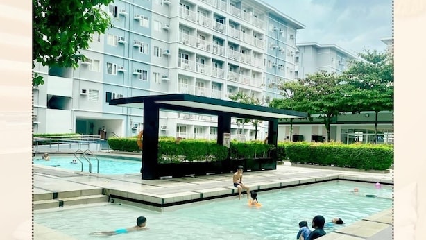 A swimming pool area with a modern building in the background.