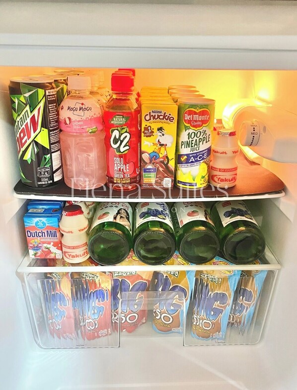 Un refrigerador lleno de diversas bebidas, incluyendo Mountain Dew, Mogu Mogu, C2, Nestle Crunch, jugo de piña 100% Del Monte y Yakult.