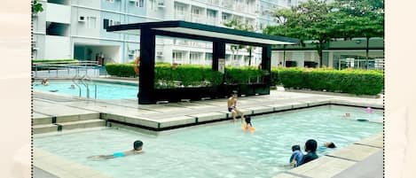A swimming pool area with a modern building in the background.