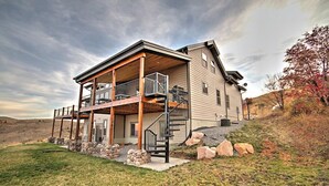 A two-story house with a covered porch, a staircase, and a stone foundation.