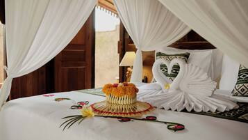 A bed with a decorative swan pillow, a woven basket with flowers, and a canopy.