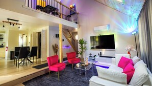 A spacious living area with a high ceiling, a balcony, a dining area, and a modern kitchen. - Deer Trails Retreat•Games•Fire Pit•Near Kalahari•Pocono•Camelback (Pocono Summit)