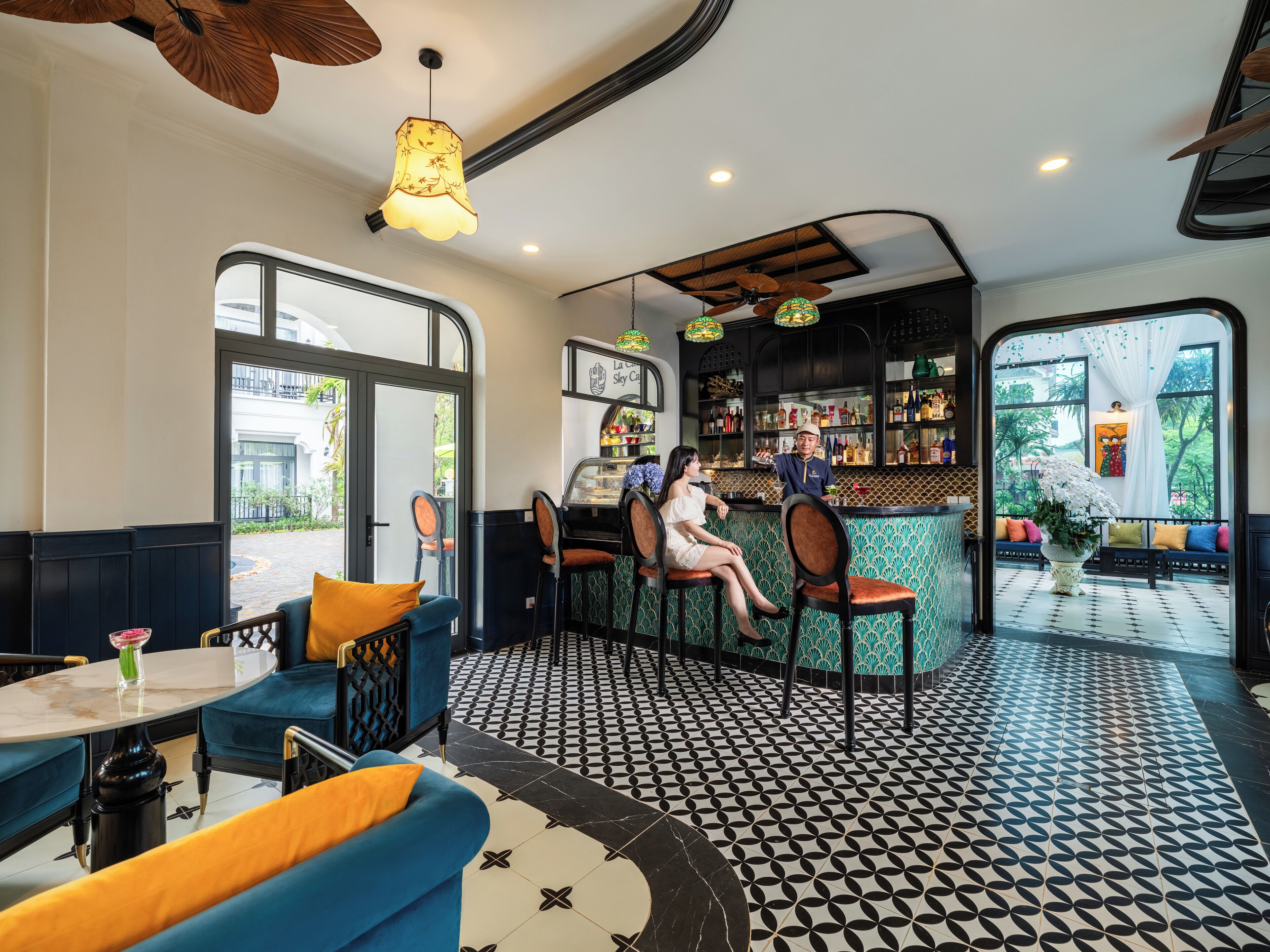 A bar area with seating, a bartender, and a view of the outdoors.