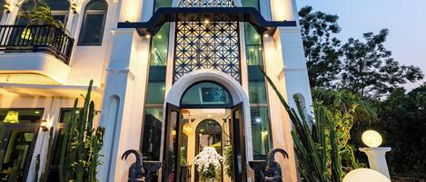 A modern building with a large entrance, a decorative archway, and a well-lit facade.