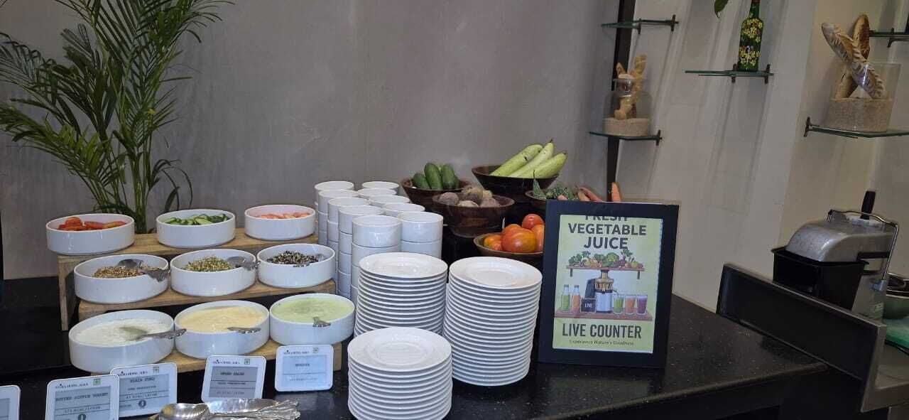 Un buffet proposant une variété de plats et un panneau indiquant un espace de préparation en direct.