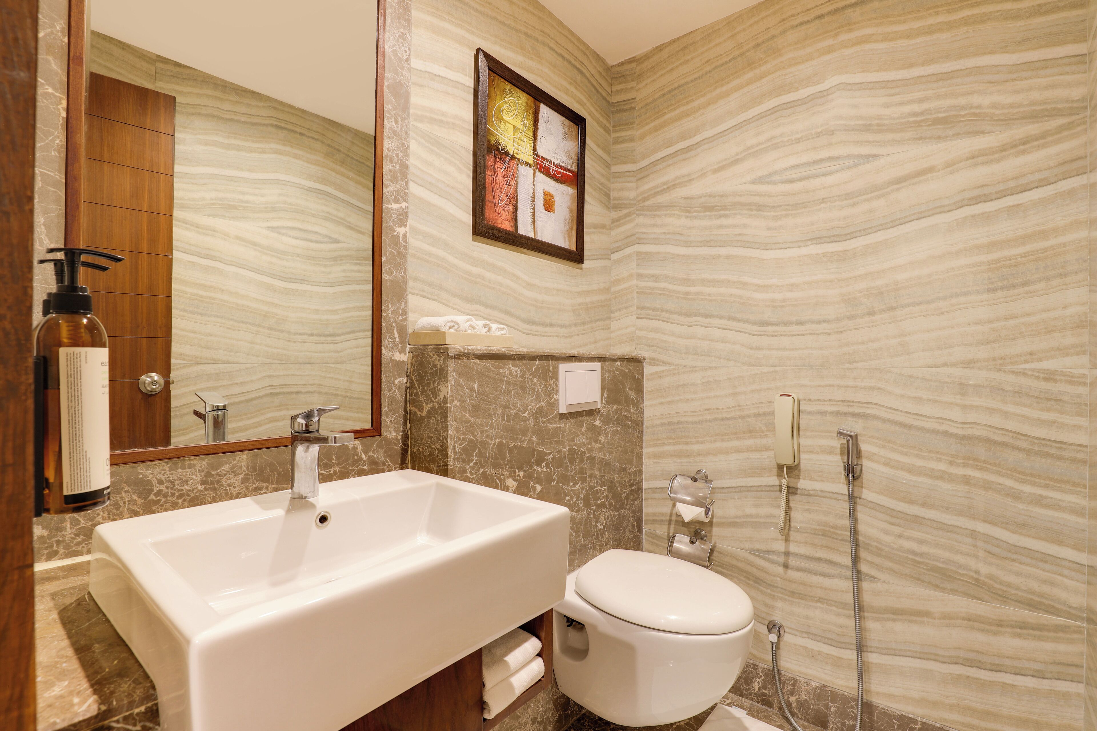 Un baño con un lavamanos grande blanco, un inodoro y una ducha.