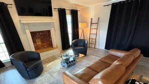 A modern living room with a leather sofa, a glass coffee table, and a record player.