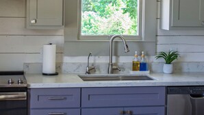 A kitchen with a built-in sink, a wooden table, and cabinets. - Immaculately restored home in Downtown Brenham (Brenham)