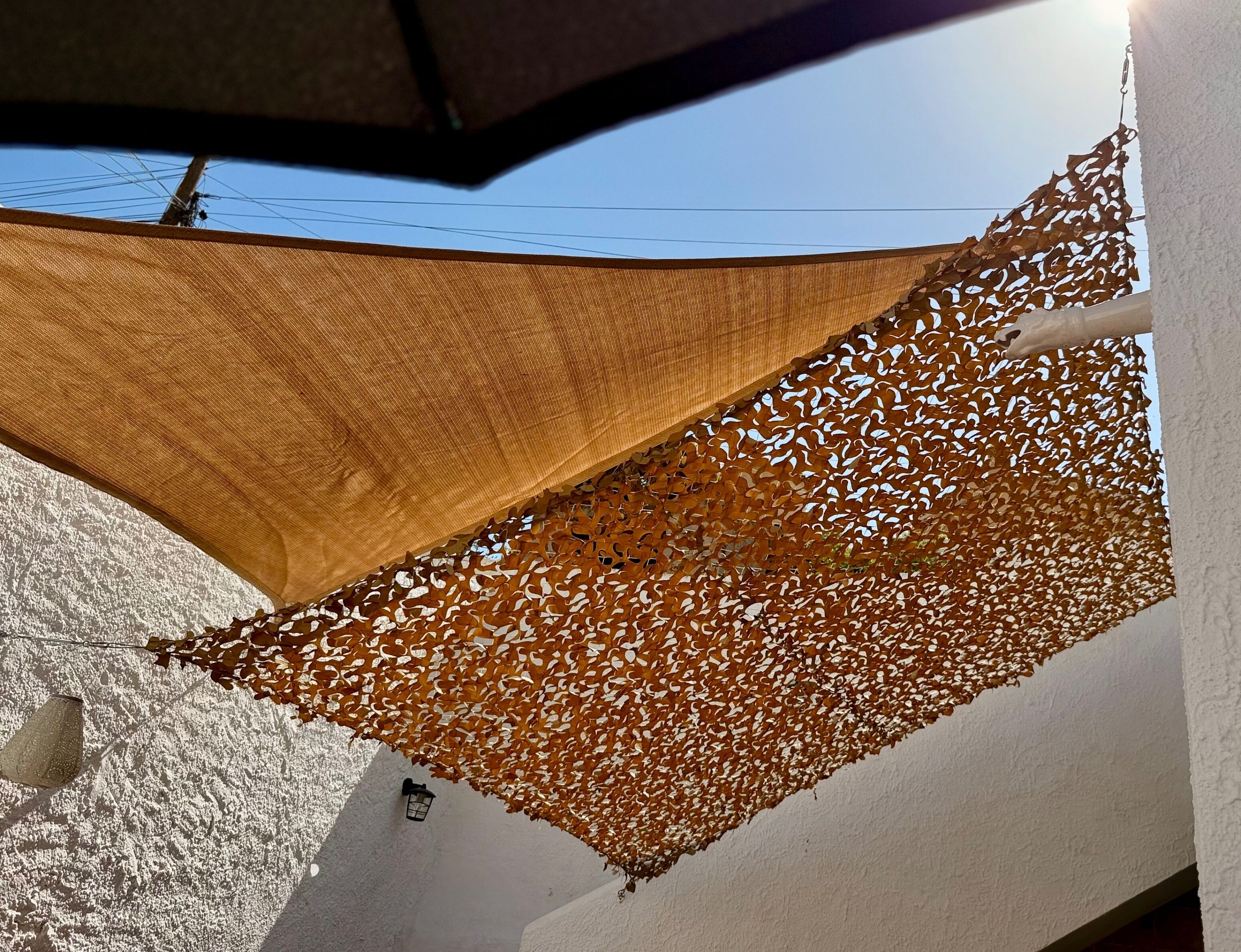 Une pièce avec un mur blanc, un auvent brun et un petit luminaire fixé au mur.