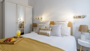 Une chambre à coucher avec un lit, des lampes de chevet, une armoire et un plateau contenant de la nourriture et des boissons.