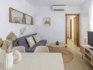 Een moderne woonkamer met een grijze bank, een ronde salontafel en een tv-meubel.