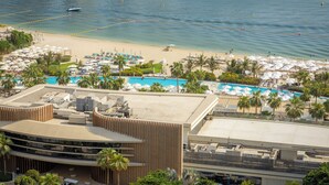 Un resort con zona de piscina, playa y un edificio de diseño moderno.