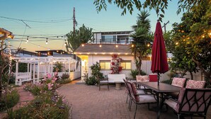 A patio area with a table and chairs, surrounded by plants and a white fence. - Bird Rock, La Jolla Whitewater w/AC (La Jolla)