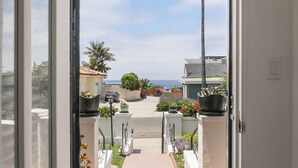 A view from inside a door looking out to a street with houses, a palm tree, and a clear sky. - Bird Rock, La Jolla Whitewater w/AC (La Jolla)