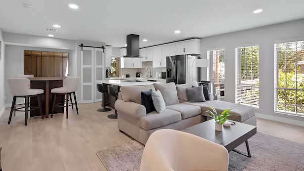 A modern apartment with a kitchen, dining area, and living room.