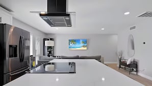 A modern kitchen with a large island, built-in appliances, and a minimalist design.