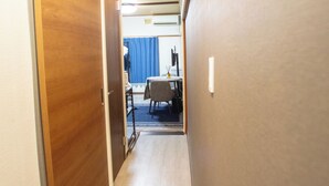 A narrow hallway with wooden doors on one side and a blue curtain in the background. - Full-rental, ideal for short- to medium-term stays for sightseeing, business trips, study abroad, etc./Apartment in Amakubo, Tsukuba City (Tsukuba City Amakubo 4chome)