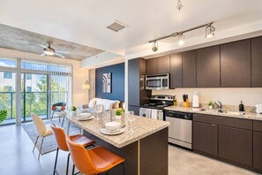 A modern kitchen with dark wood cabinets, stainless steel appliances, and a granite countertop.