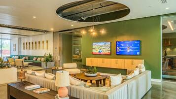 A modern lobby with a curved ceiling, seating area, and a television mounted on the wall.