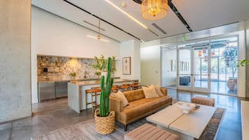 A modern living space with a kitchen, a sofa, and a dining area.