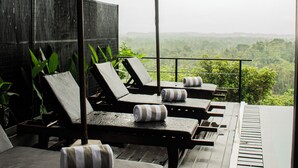 A deck with lounge chairs and umbrellas, overlooking a lush landscape. - Villa Hillcrest (Weligama)