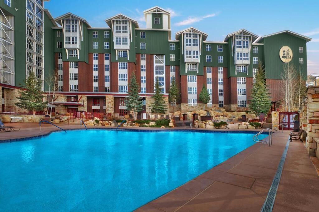 A hotel with a large indoor pool, stone facade, and multiple balconies.