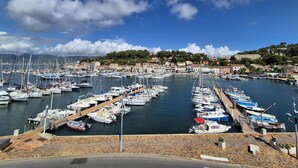 A marina with numerous boats docked, surrounded by buildings and a hilly landscape. - 2-Bedroom Apartment with Sea View – Everything Within Walking Distance (ST MANDRIER SUR MER)