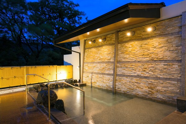 A spa area with a stone wall, a wooden fence, and a metal railing. - Jinzukyo Kasuga Onsen Tominowa (Toyama)